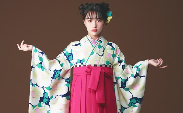 着物と袴のレンタルセット商品画像。袴はピンク色。着物は紺色。椿づくし柄のデザイン。