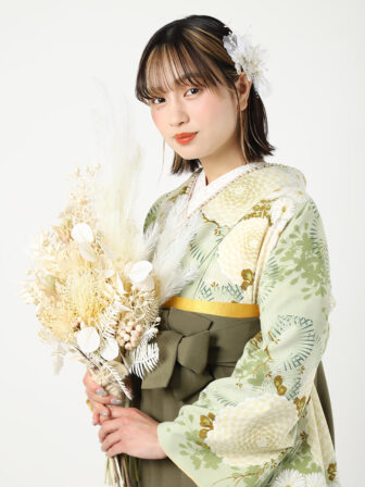着物と袴のレンタルセット商品画像。袴はカーキ色。着物は若葉色。万寿菊柄のデザイン。上半身アップ画像。