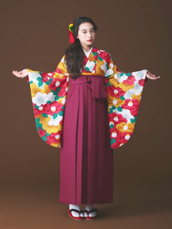 着物と袴のレンタルセット商品画像。袴はえんじ色。着物は金茶色。新梅椿柄のデザイン。