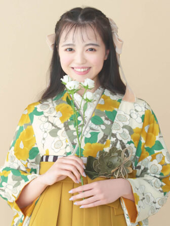 着物と袴のレンタルセット商品画像。袴はカラシ色。着物はカラシ色。梅椿柄のデザイン。上半身アップ画像。