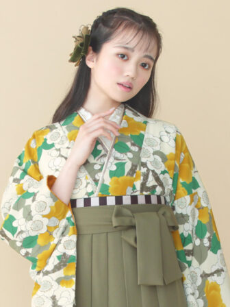 着物と袴のレンタルセット商品画像。袴はカーキ色。着物はカラシ色。梅椿柄のデザイン。上半身アップ画像。