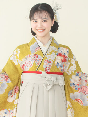 着物と袴のレンタルセット商品画像。袴はアイボリー色。着物はカラシ色。松に花丸紋柄のデザイン。上半身アップ画像。