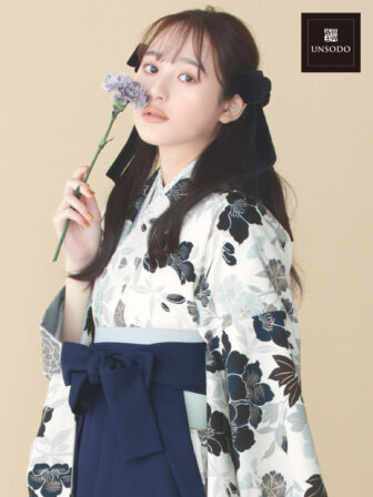 着物と袴のレンタルセット商品画像。袴は紺色。着物はオフ色。御所文様柄のデザイン。上半身アップ画像。
