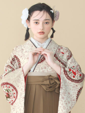 着物と袴のレンタルセット商品画像。袴はブラウン色。着物はベージュ色。小鳥更紗柄のデザイン。上半身アップ画像。