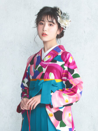 着物と袴のレンタルセット商品画像。袴はターコイズ色。着物はピンク色。デッサン椿柄のデザイン。