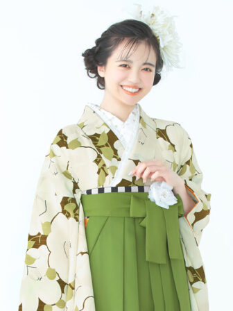 着物と袴のレンタルセット商品画像。袴は抹茶色。着物はオリーブ色。椿づくし柄のデザイン。上半身アップ画像。