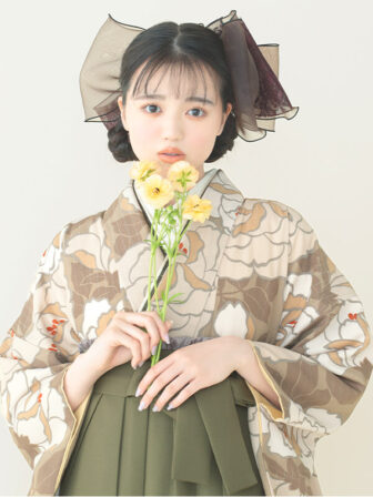 着物と袴のレンタルセット商品画像。袴はカーキ色。着物はカフェオレ色。バラ柄のデザイン。上半身アップ画像。